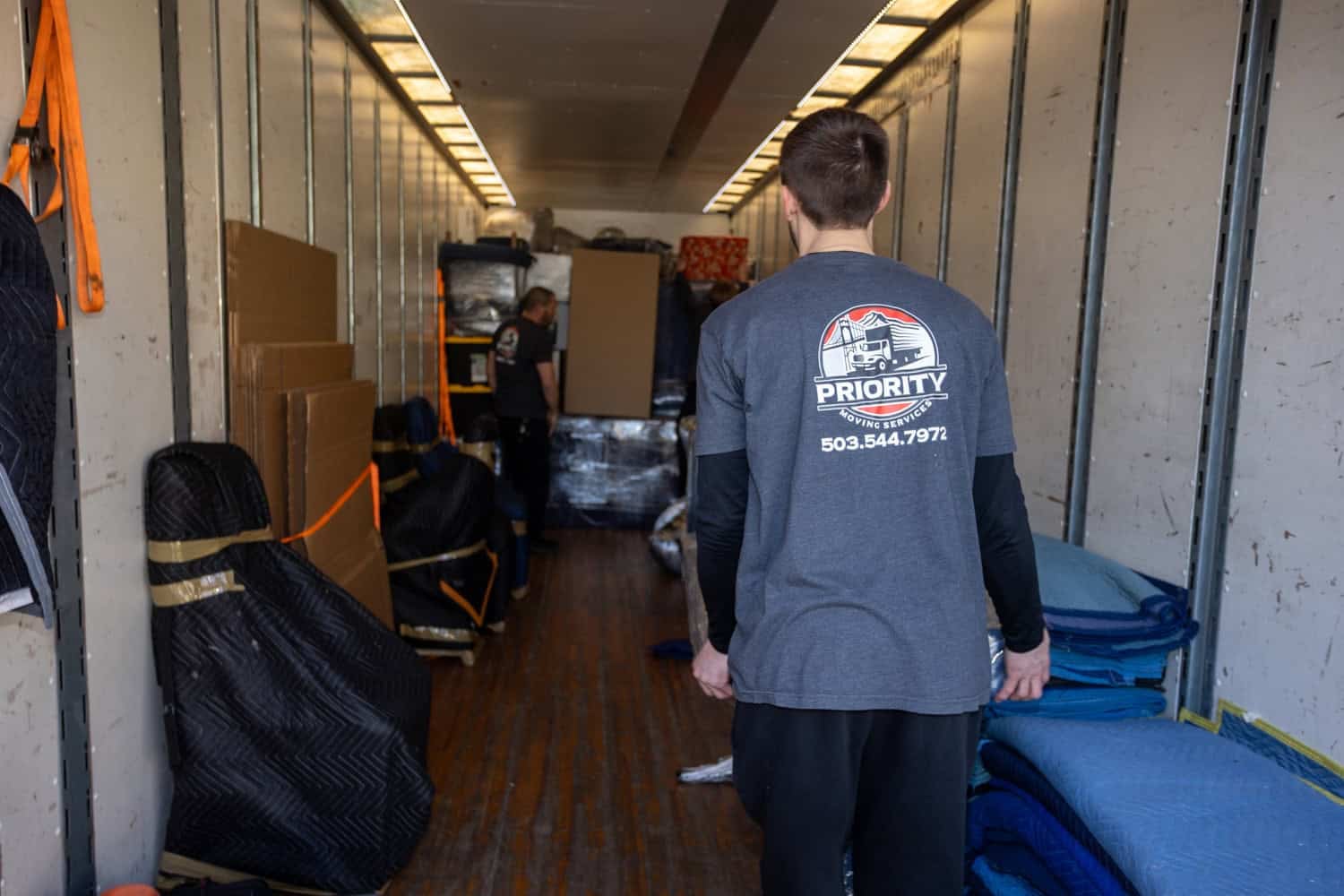 Moving crew inside truck with packed belongings, ready for a move.